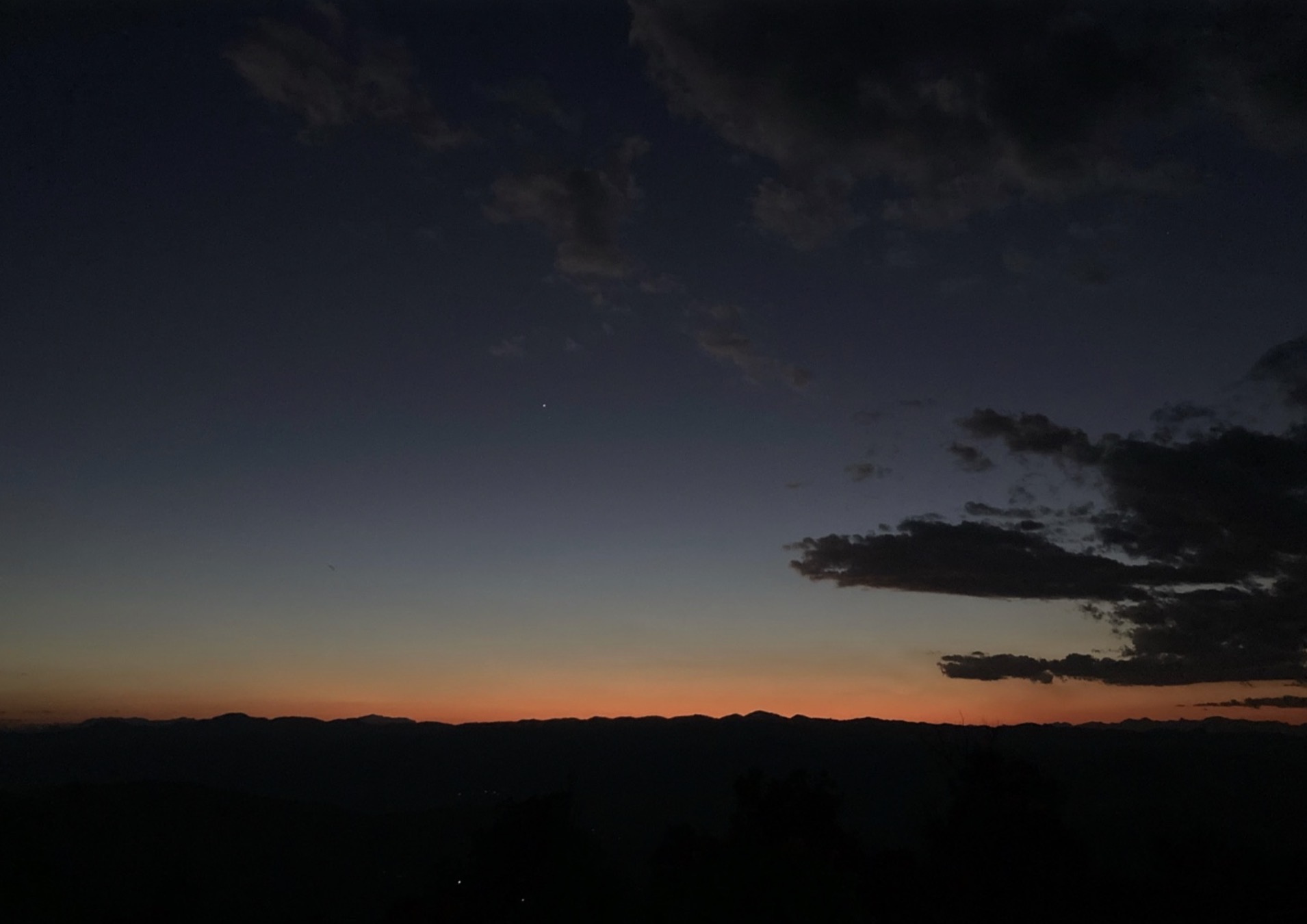 山の稜線に夕焼けが残る深い青の空
